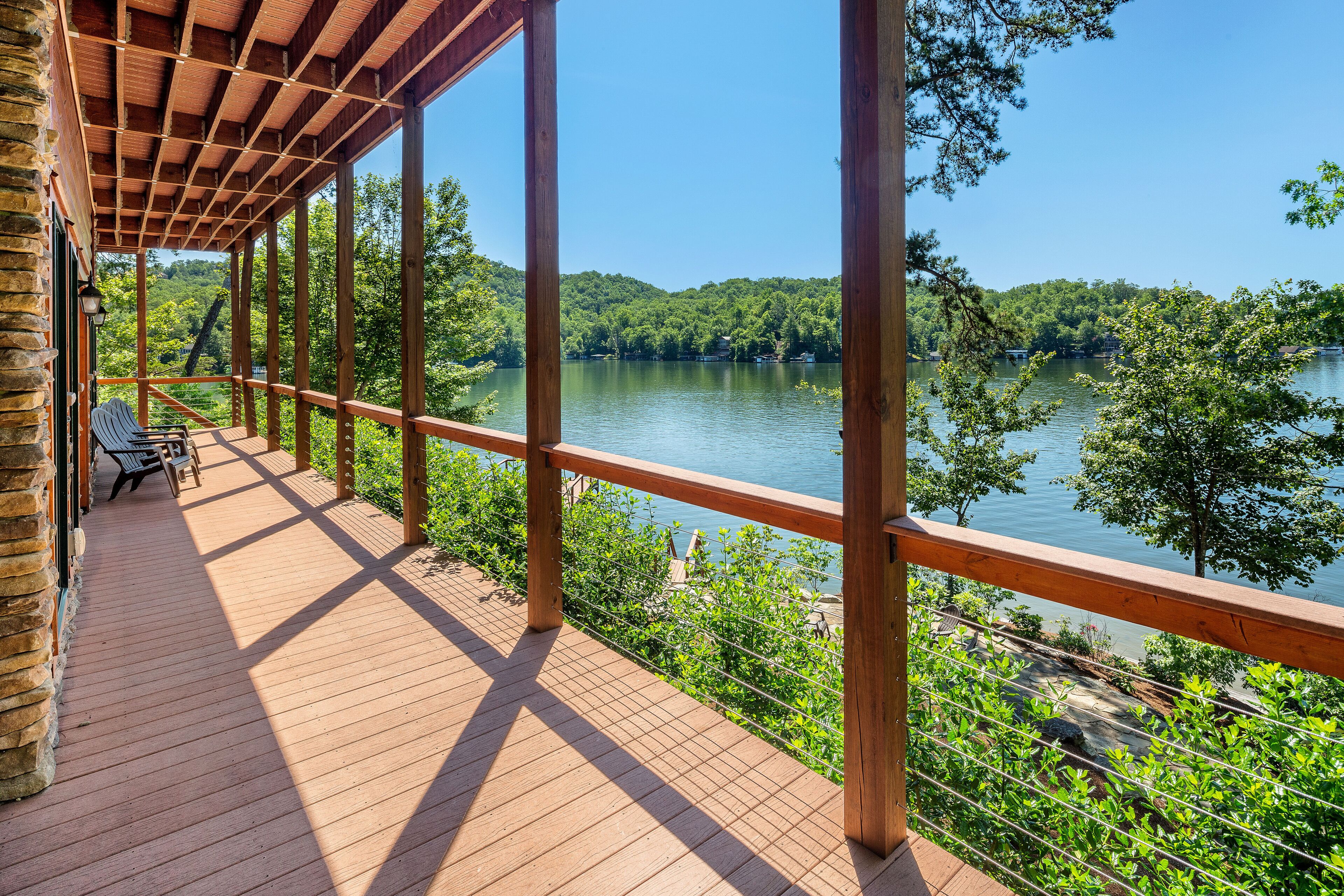 A wooden deck with a view of a lake and forest.