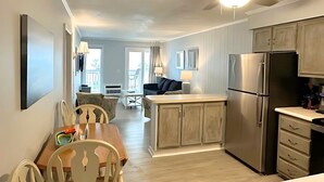 A spacious kitchen with modern appliances, a dining area with wooden chairs, and a ceiling fan. - Oceanfront Condo • 2026 Renovations! • 2 BD, 2BA (Myrtle Beach)