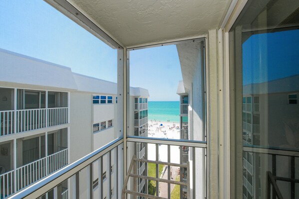 A balcony with a view of a beach and ocean.