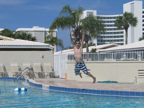 A man jumping into a pool with a 5 ft depth marker.