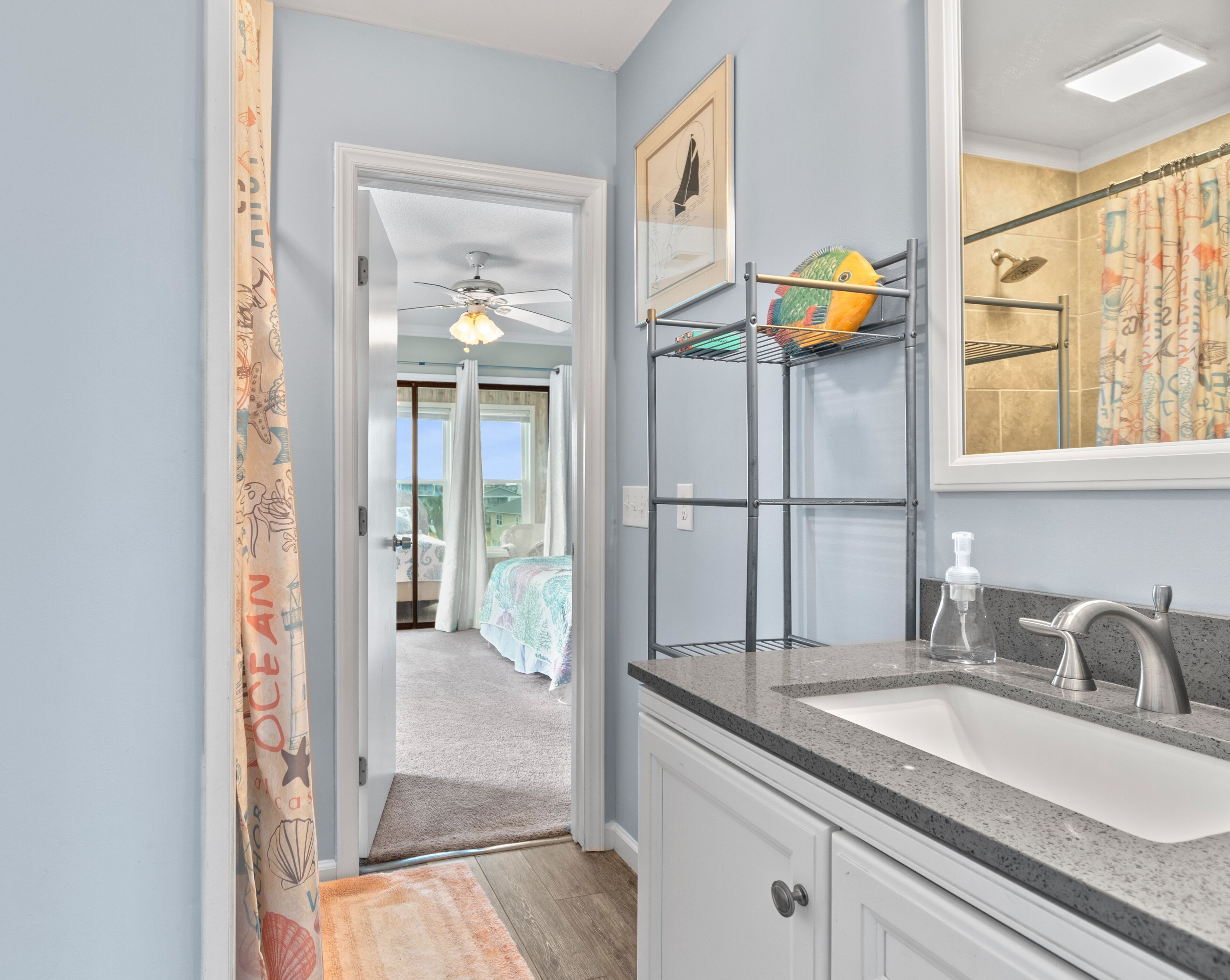 A bathroom with a sink, mirror, and a ceiling fan.