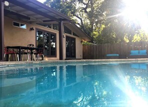 A swimming pool with a covered patio area, a wooden fence, and a clear sky. - Escape to this Redding 3-Bedroom home with Outdoor Pool and Spa (Redding)