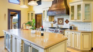 A spacious kitchen with a large island, white cabinetry, and a prominent stainless steel range hood. - Farm Stay Villa on 55 Acres // Pool, Hot Tub & Complimentary Wine Tasting (Healdsburg)