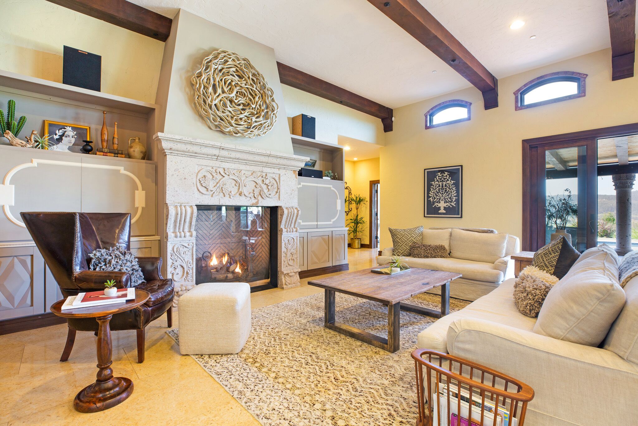 A spacious living room with a fireplace, comfortable seating, and a decorative rug.