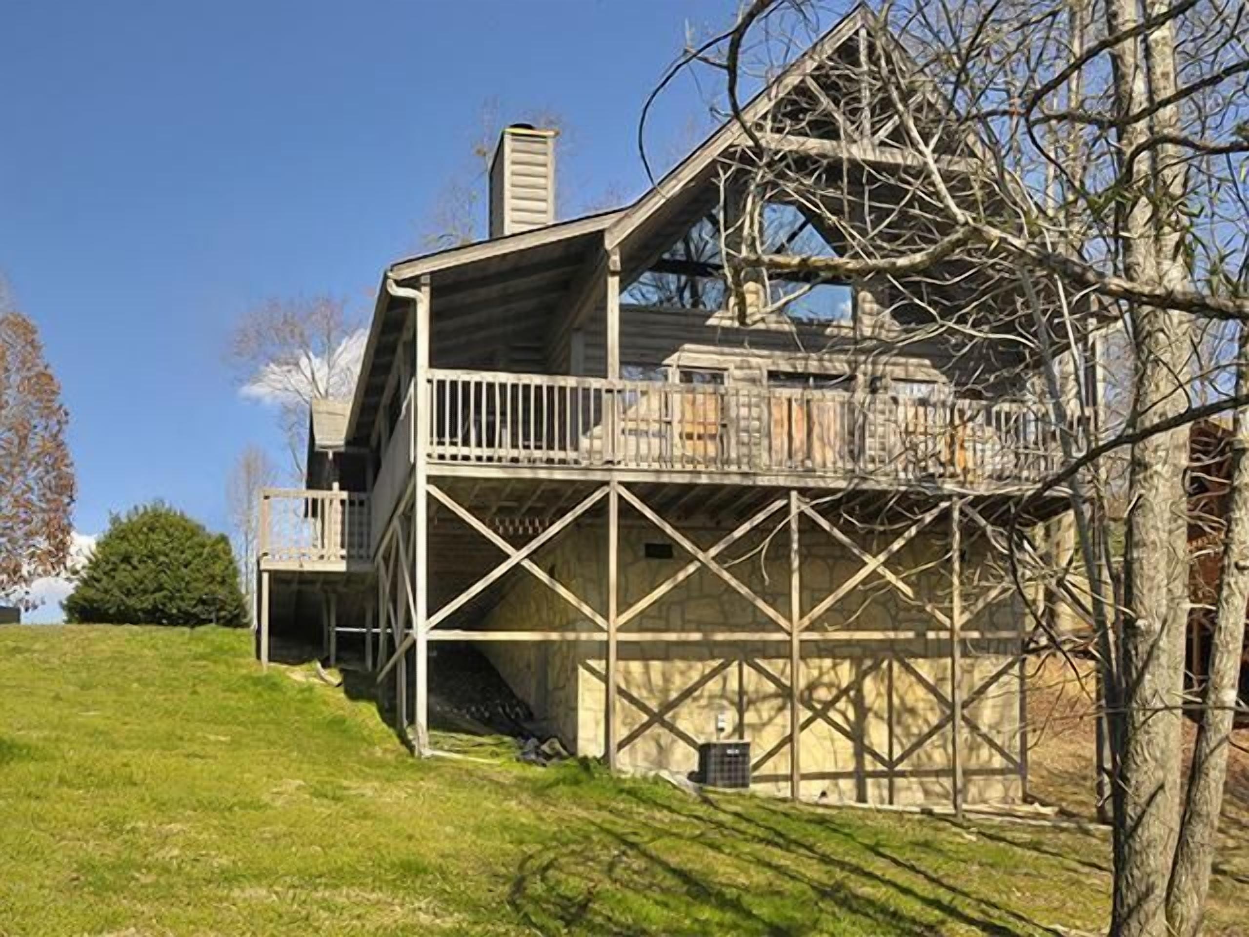 Una casa grande y rústica de madera con un balcón y una chimenea.