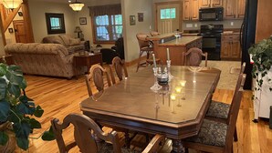 A spacious living room with a wooden dining table, comfortable seating, and a kitchen area with wooden cabinets and appliances. - LOCATED IN ABINGDON, VA - PRIVATE, TRANQUIL SETTING (Abingdon)