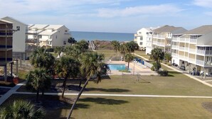 A resort with a pool, palm trees, and ocean views. - Gulf View 4/4.5-Seacliffs /dog friendly/community pool/ steps to beach-SPECIALS! (Port St Joe)