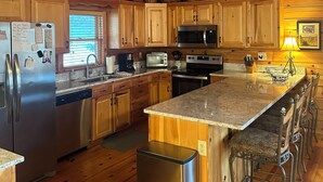 A spacious kitchen with wooden cabinets, stainless steel appliances, and a large island.