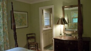A bedroom with a four-poster bed, a bedside table with a lamp, a dresser, and a mirror. There is a chair and a door leading to another room. - Relaxing Mountain Get Away (Saluda)