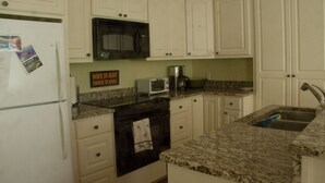 A kitchen with white cabinets, a black microwave, a toaster, and a sink. - Relaxing Mountain Get Away (Saluda)