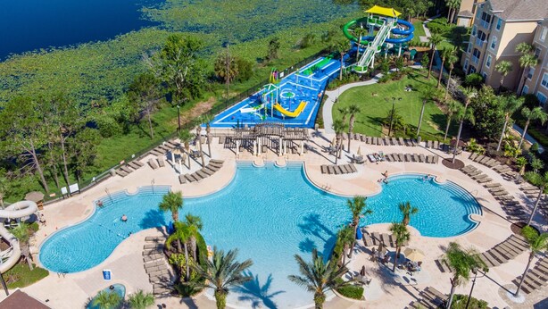 A resort with a large pool, a water park, and a well-maintained lawn area. - Paradise Villa, No rear neighbors, Minutes from Disney (Kissimmee)