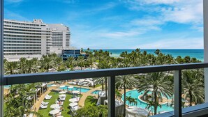 Een resort met meerdere zwembaden, palmbomen en uitzicht op de oceaan.