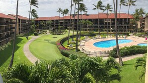 Un resort con piscina, vegetazione rigogliosa e campo da golf.