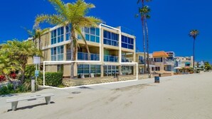 Un hotel de varios pisos con vista a la playa, que cuenta con un balcón y una piscina.