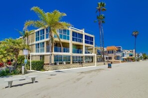 Ein mehrstöckiges Hotel mit Blick auf den Strand, ausgestattet mit einem Balkon und einem Poolbereich.