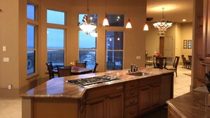 A spacious kitchen with a large island, multiple windows, and pendant lighting. - Gulf Front, 3 Gulf Front Master Suites, Heated Balcony Pool  (Navarre)