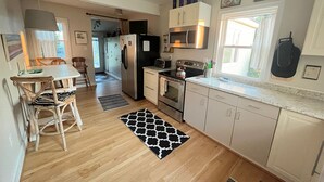Eine moderne Küche mit Essbereich, Holzboden und einem gemusterten Teppich.