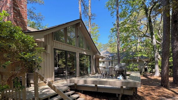 A modern house with a deck, a covered outdoor seating area, and a staircase leading to the entrance. - Private, Immaculate 4BR/4BA Home—community pool/tennis, minutes to beach/golf (Hilton Head Island)