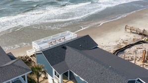 A beachfront property with a covered patio overlooking the ocean. - Charleston Coast Vacations "Seascape Wonder" (Folly Beach)