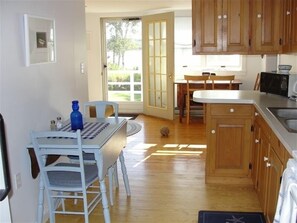 Enjoy meals in the kitchen with a dining table and chairs nearby, and access to a patio area.