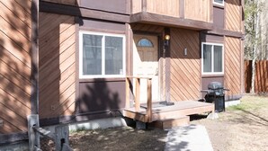 Una casa a due piani in legno, con un portico anteriore, un garage e un'antenna parabolica.