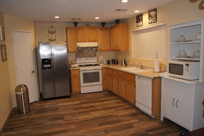 Enjoy cooking in this well-equipped kitchen with a refrigerator, oven, microwave, and sink.