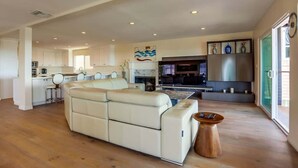 A spacious living area with a sofa, a coffee table, and a kitchen in the background.
