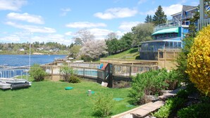 Une propriété située au bord de l’eau, dotée d’une terrasse en bois, d’une piscine et offrant une vue sur le lac.
