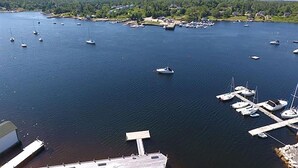 Un port de plaisance où sont amarrés de nombreux bateaux, entouré d’un paysage boisé.