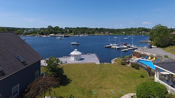 Un quartier résidentiel comprenant une maison, une piscine et un port de plaisance avec des bateaux.