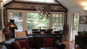 Un salon spacieux avec un grand canapé en cuir, une table basse en bois et un lustre.