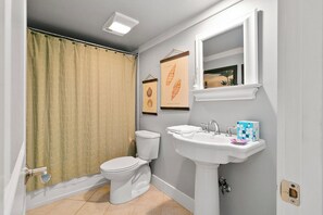 A bathroom with a toilet, sink, and shower curtain. - Stunning Condo in Plantation Club with Views of the Golf Course and On-site Amenities! (Hilton Head)