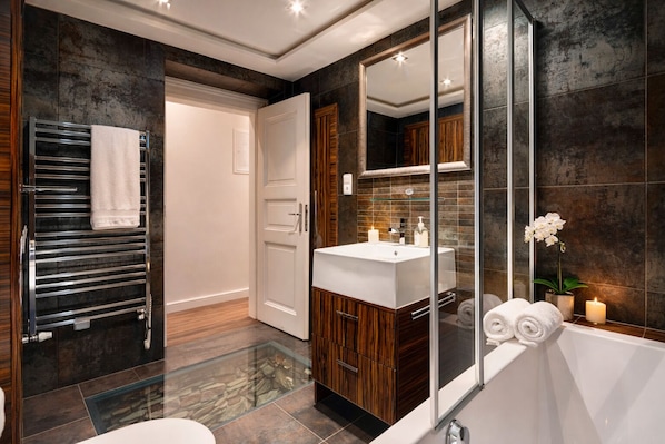 A modern bathroom with a glass-enclosed shower, a large mirror, a wooden vanity, and a white bathtub. - Romantic Prague Escape · 3min to Old Town Square · AC (Praha)