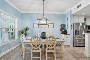 A dining area with a table set for four, surrounded by chairs with a unique design.