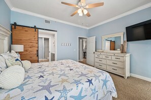 Un dormitorio con cama, cómoda y ventilador de techo.