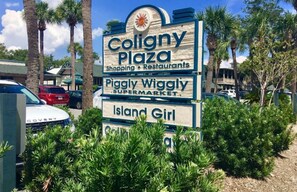 Señal de Coligny Plaza con tiendas y restaurantes, incluyendo el supermercado Piggly Wiggly y Island Girl.
