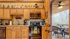 Una cucina con mobili in legno, un fornello e diverse bottiglie sul bancone.