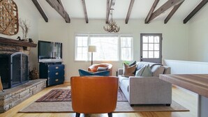 A living room with a fireplace, a television, and a sofa. - The Dala House | Scandinavian Retreat in Blowing Rock (Blowing Rock)