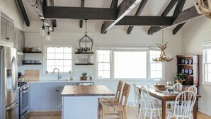 A spacious kitchen with a central island, wooden chairs, and a dining table. - The Dala House | Scandinavian Retreat in Blowing Rock (Blowing Rock)