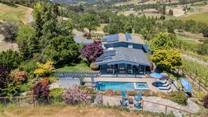 A house with a swimming pool, solar panels, and a patio with lounge chairs. - Wine Country Retreat with Pool, Vineyard, Trampoline, Putting Green and Hot Tub (Santa Rosa)