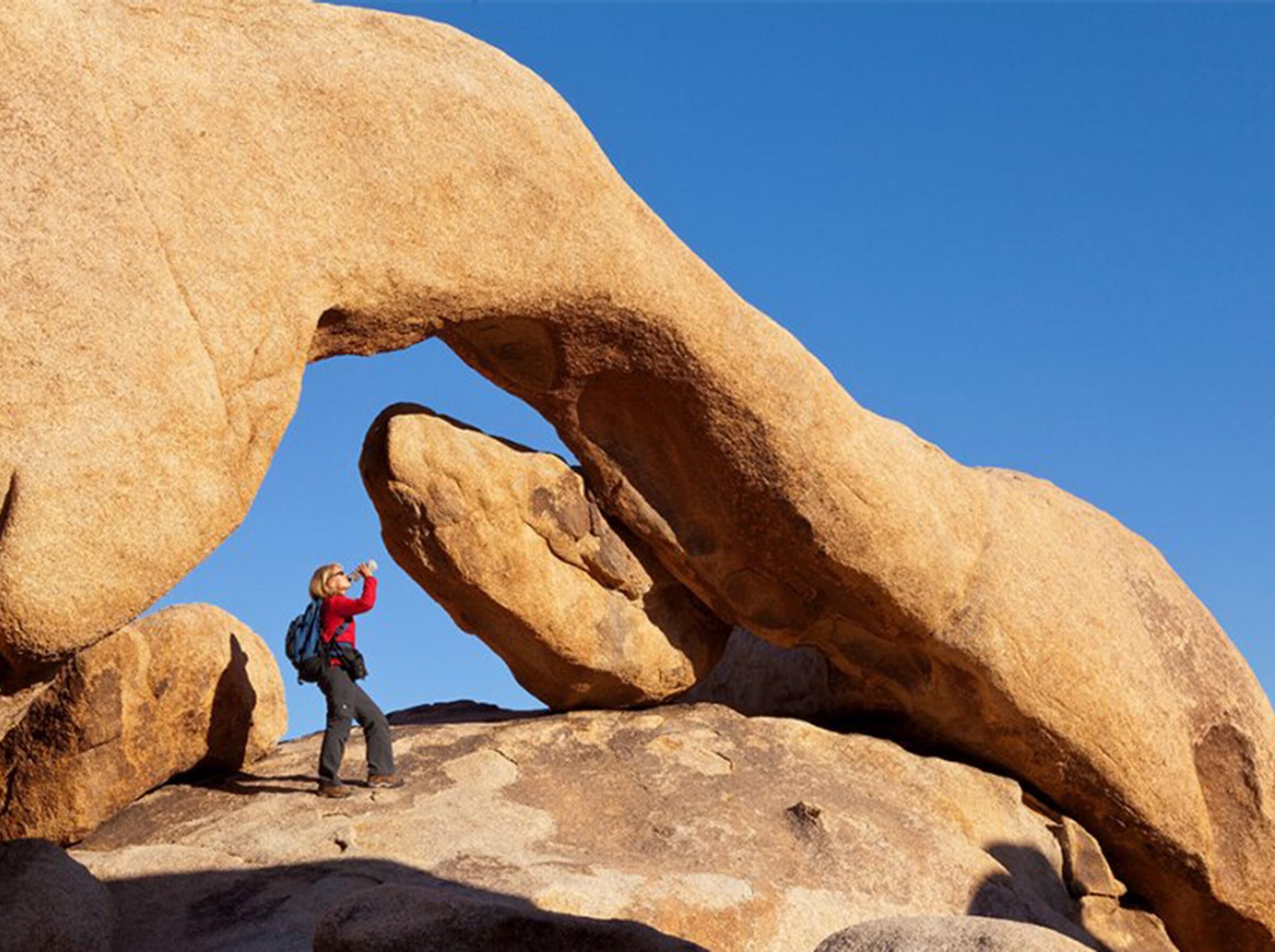 A person climbing a large rock formation.