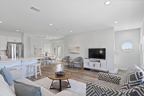 A modern living room with a sofa, a coffee table, and a TV. - Beautiful Beach House  - Private Pool -Great Views -Gulf of America (Gulf Shores)