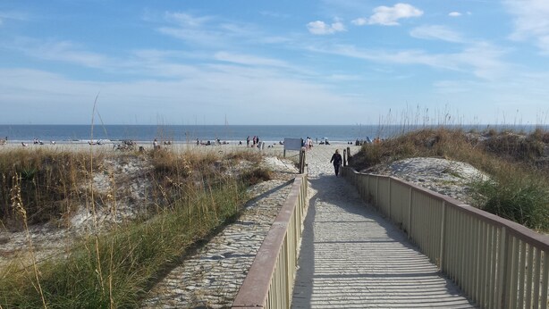 A beach pathway leading to the shore with people walking and sitting on the sand. - Shipyard: 271 Evian Island Villa-Relaxing Setting Weekly Rates Discounted (Hilton Head Island)