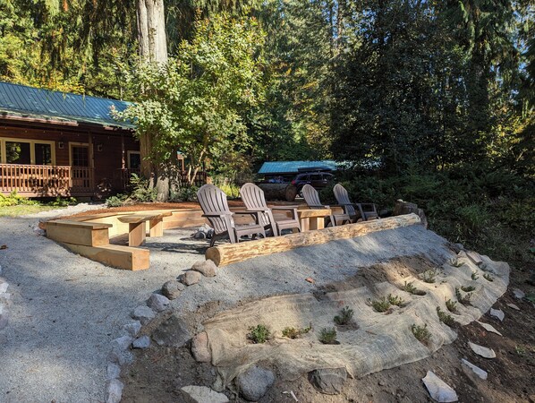 Un chalet rustique doté d’une terrasse et d’un espace salon extérieur.