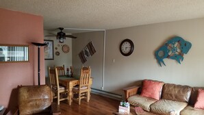 A living room with a wooden dining table, chairs, a sofa, and a coffee table. - Resort Condo/Relax/ enjoy the outdoors/mountains. Easy access in Winter/ Ruidoso (Ruidoso)