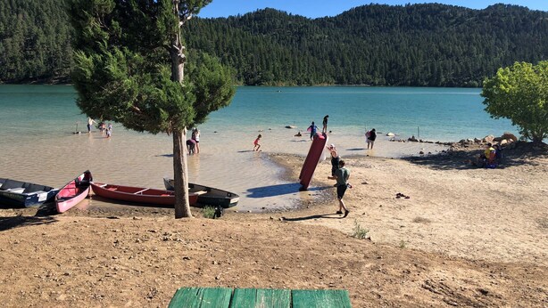 A lakeside beach with boats, people, and a forested hill in the background. - Resort Condo/Relax/ enjoy the outdoors/mountains. Easy access in Winter/ Ruidoso (Ruidoso)