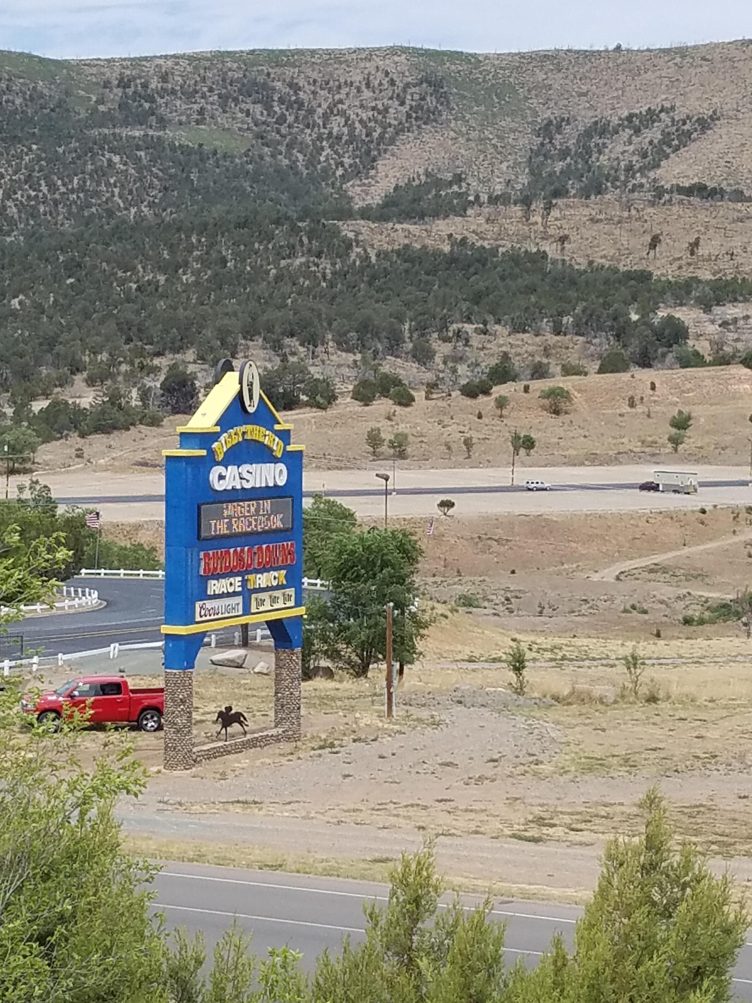 Une enseigne de casino avec une publicité pour des courses de chevaux, le tout situé au milieu d’un paysage désertique.