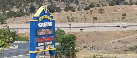 Une enseigne de casino avec une publicité pour des courses de chevaux, le tout situé au milieu d’un paysage désertique.