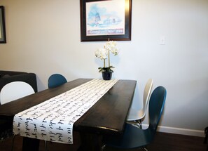 A dining table with a table runner featuring handwritten messages, surrounded by chairs.