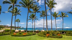 A resort with palm trees, beach view, and lounge chairs. - The Maui Escape - Spectacular 2.5 Bdr Penthouse -Oceanfront Resort-Owner Direct! (Wailea)